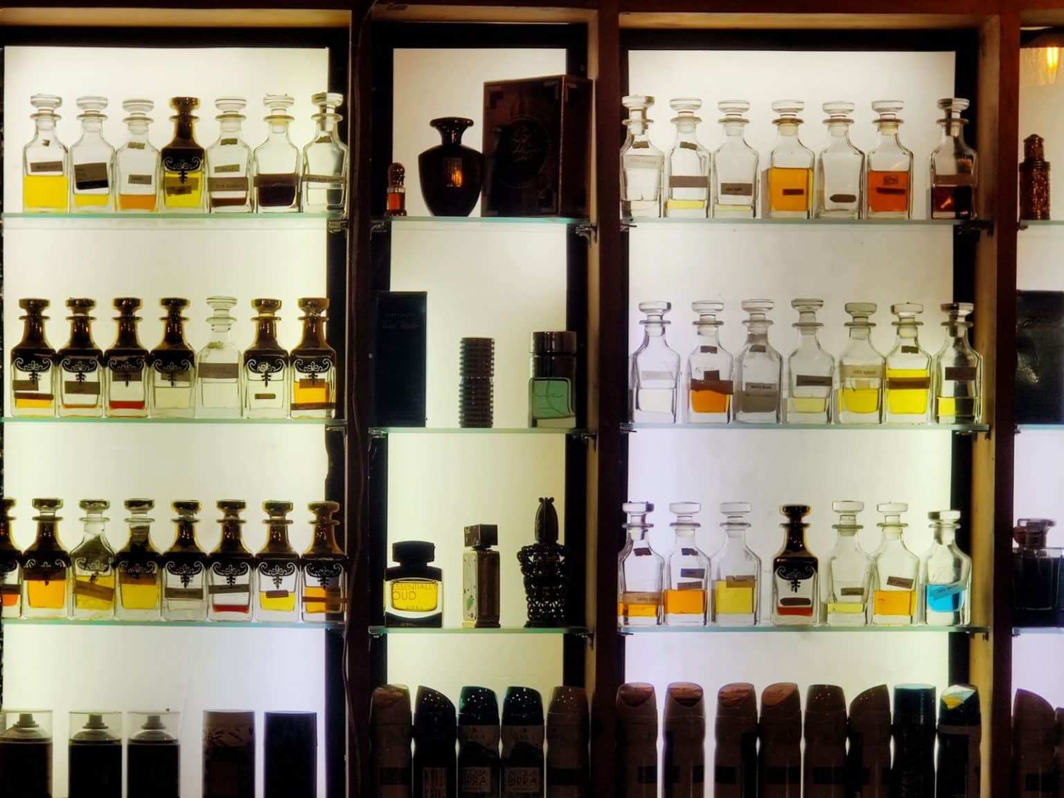 Rows of perfume bottles displayed on retail shelves