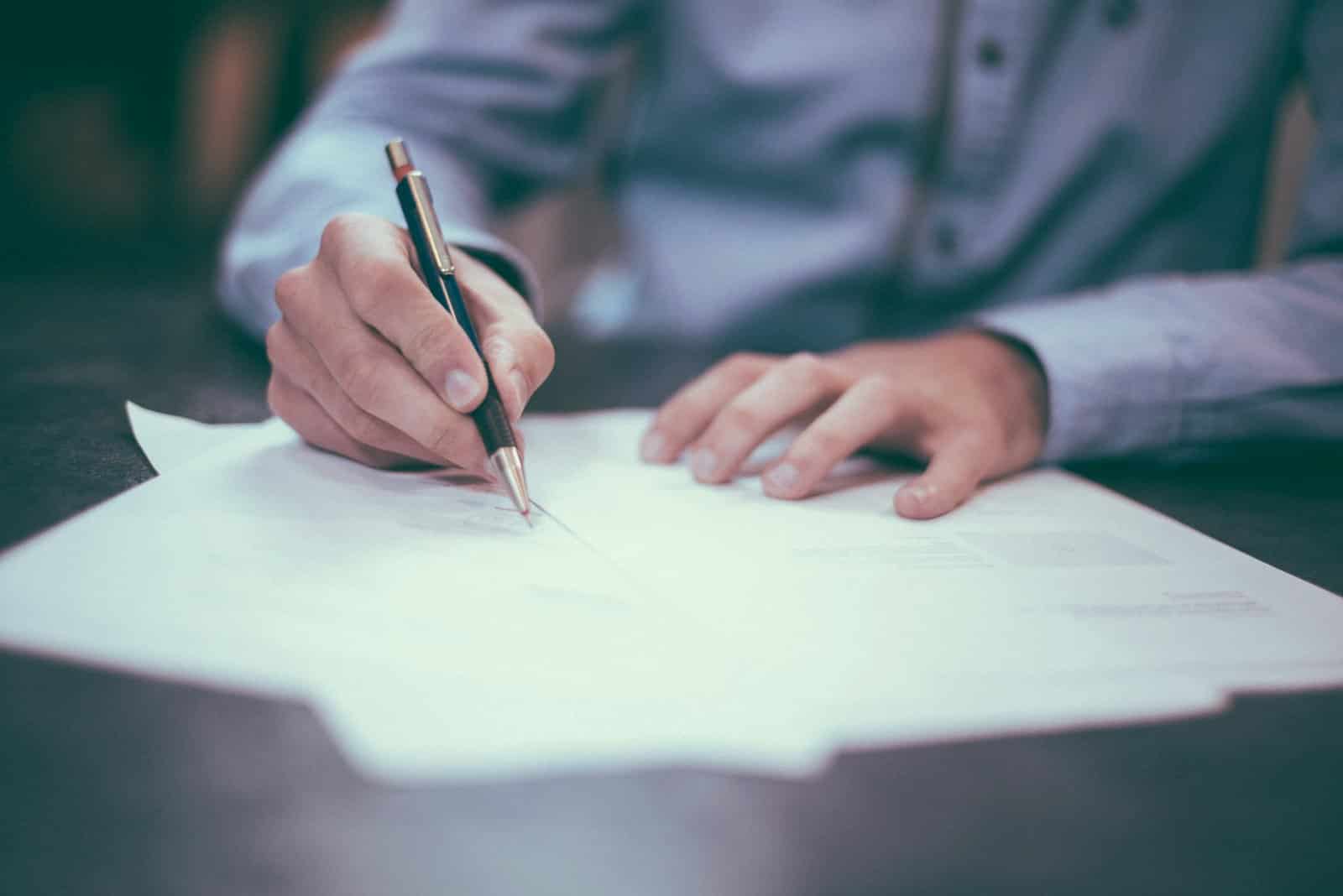 A person checking and signing a printed document at a desk