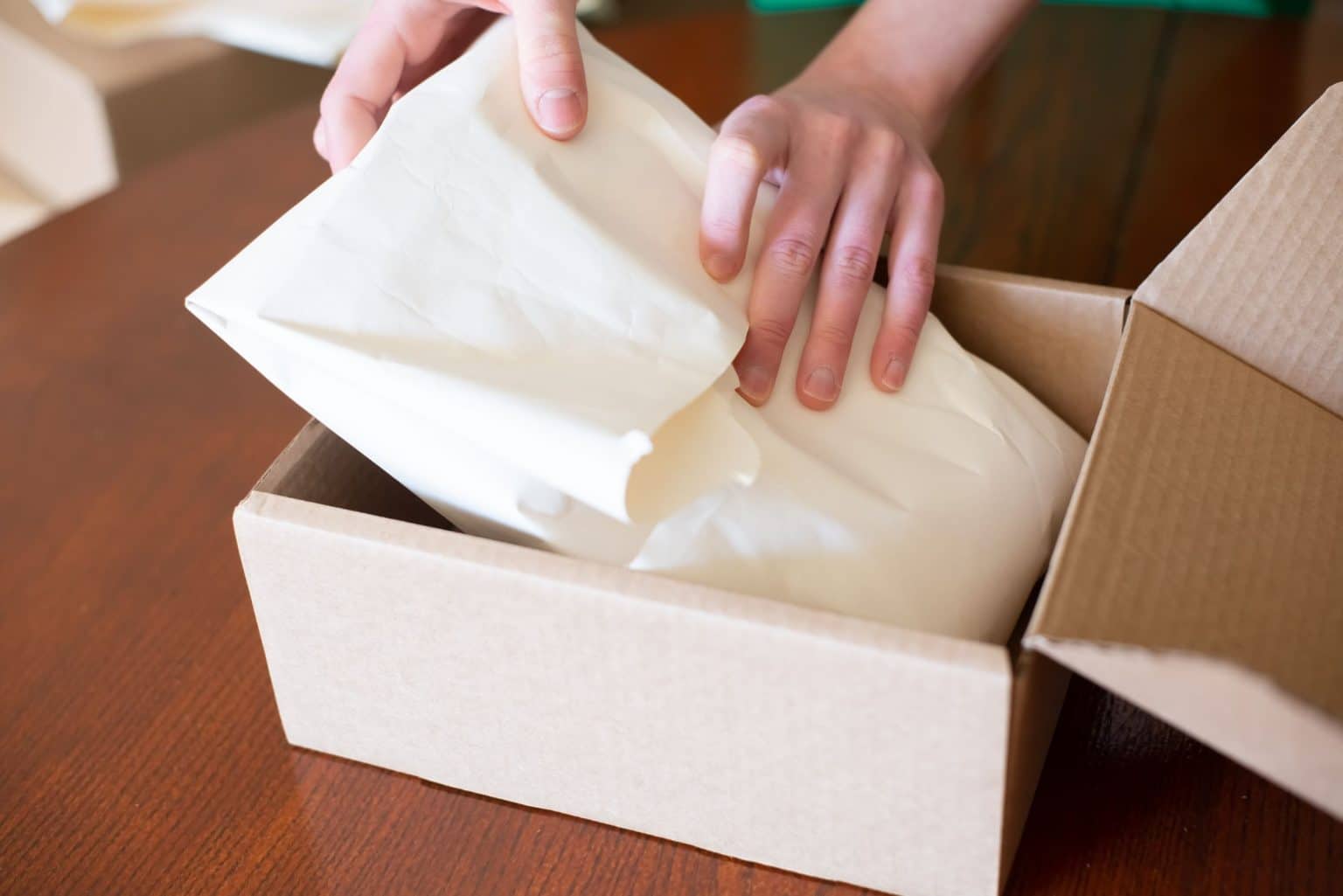 Online seller packing a customer order into a shipping box